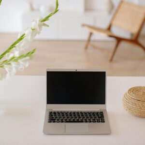 Modern laptop on a clean white table with a cozy room background.